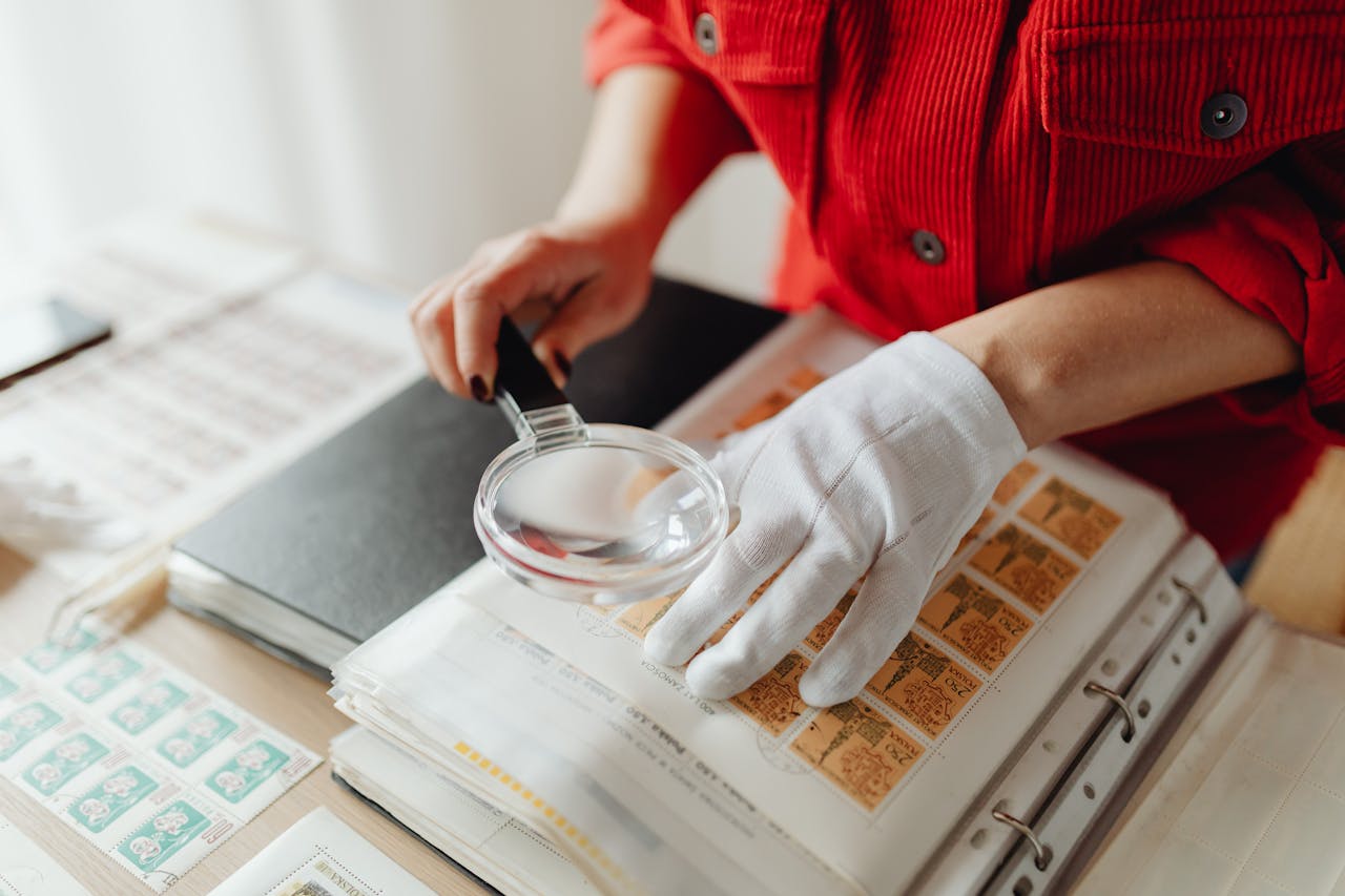 A Woman Using a Magnifying Glass on Postage Stamps